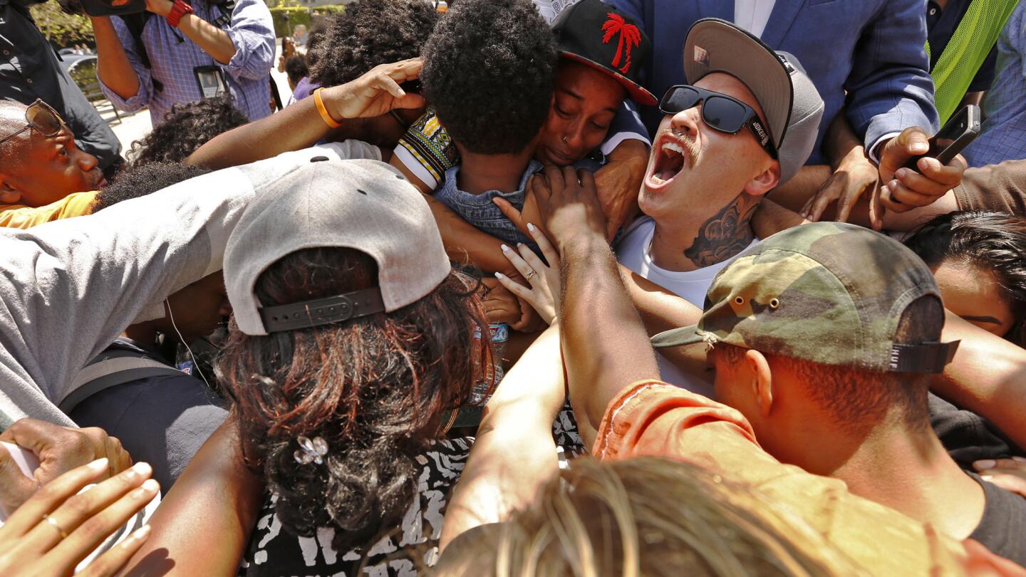 Jasmine Abdullah, top center, is surrounded by the chanting crowd outside the Los Angeles Police Department headquarters Tuesday.