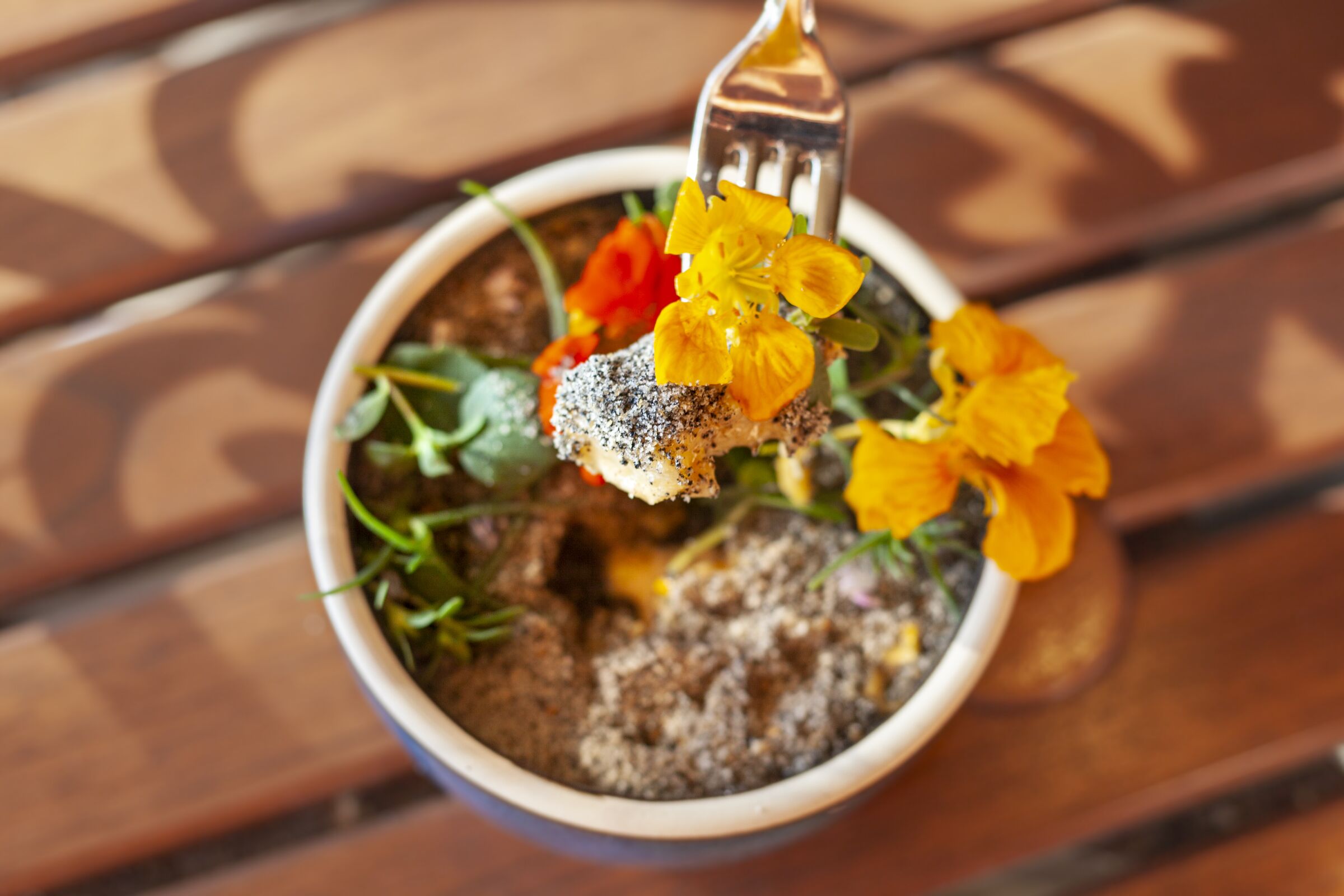 A decadent ricotta gnudi dish disguised as an edible flower pot at Avant restaurant in Rancho Bernardo.
