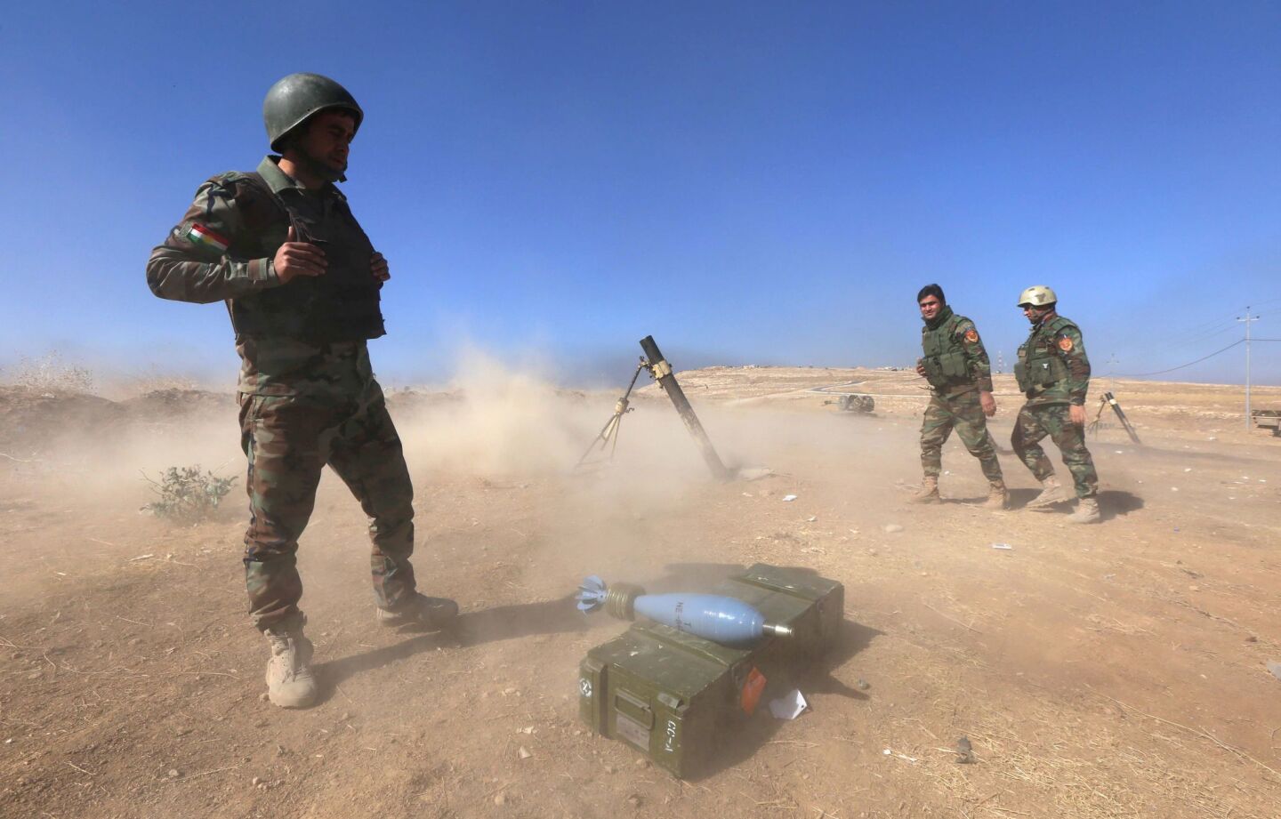 Iraqi Kurdish Peshmerga fighters fire a mortar shell from Mount Zardak.