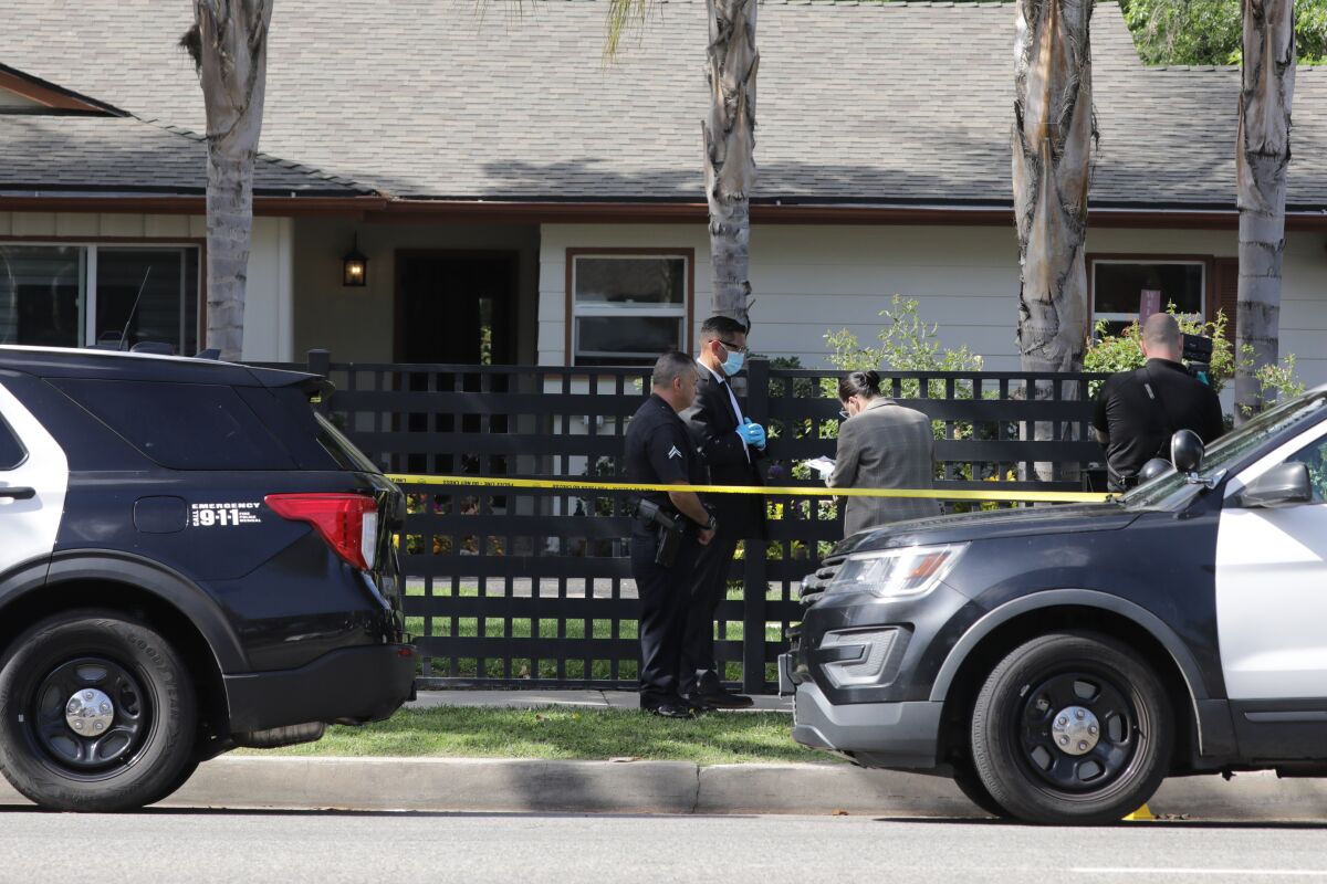 Police cars and officers outside a home.
