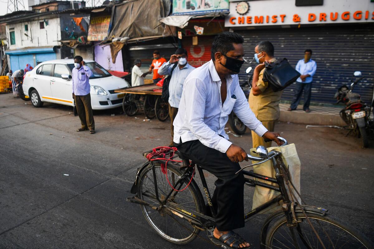 A cyclist rides past a bus stop outside the Dharavi slum in Mumbai, India, during the nationwide lockdown to combat the coronavirus.