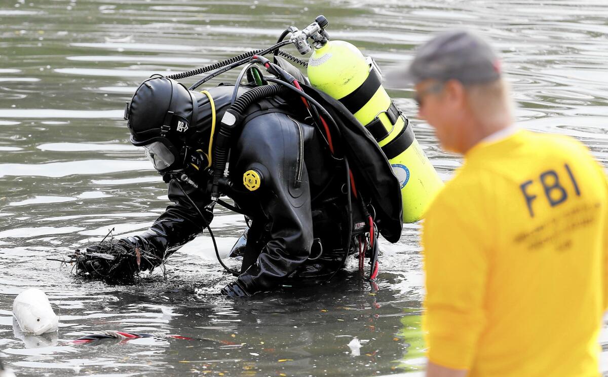 An FBI dive team on Thursday searches for electronic devices or other evidence possibly left in Seccombe Lake, about two miles north of the Inland Regional Center in San Bernardino.