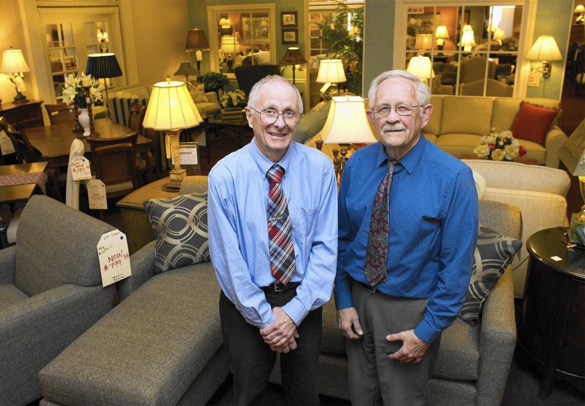 From left, John and Jim Garrett pose for a portrait at H.J. Garrett Furniture in Costa Mesa. The store was first opened in 1960 by their father, Henry James Garrett. The brothers have decided to retire and to close down their store.