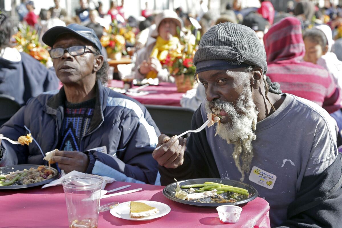 People partake of a free Thanksgiving dinner at the Los Angeles Mission's annual feast in downtown Los Angeles on Nov. 25, 2015. Serving will continue through Thanksgiving Day.