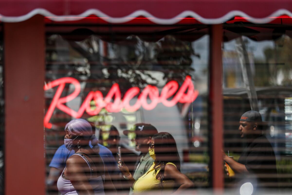People are reflected in a restaurant window.