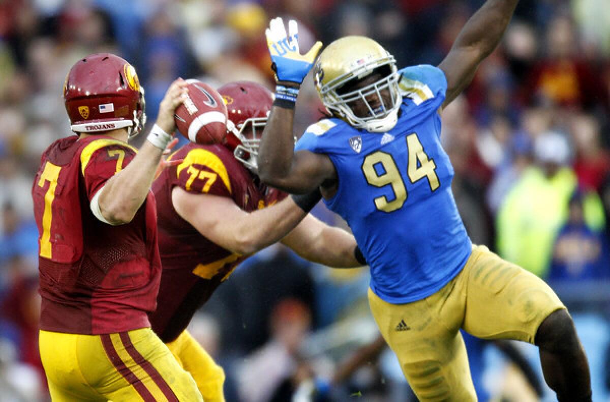 Bruins defensive end Owamagbe Odighizuwa (94) pressures USC quarterback Matt Barkley during their annual rivalry game two seasons ago.