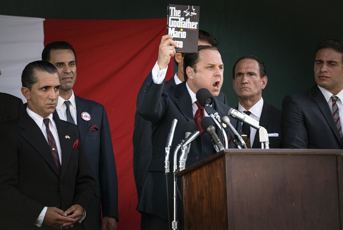 An angry man holds up a copy of 'The Godfather' at a press conference