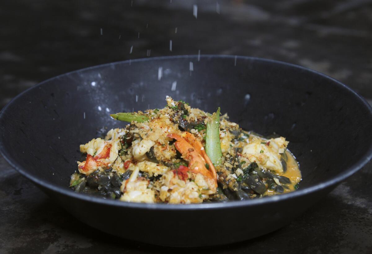 Parmesan cheese (!) is sprinkled on to black garlic udon noodles with lobster, chili, lobster bisque, and choy sum, a rule-breaking dish from Animae executive chef Joe Magnanelli. 