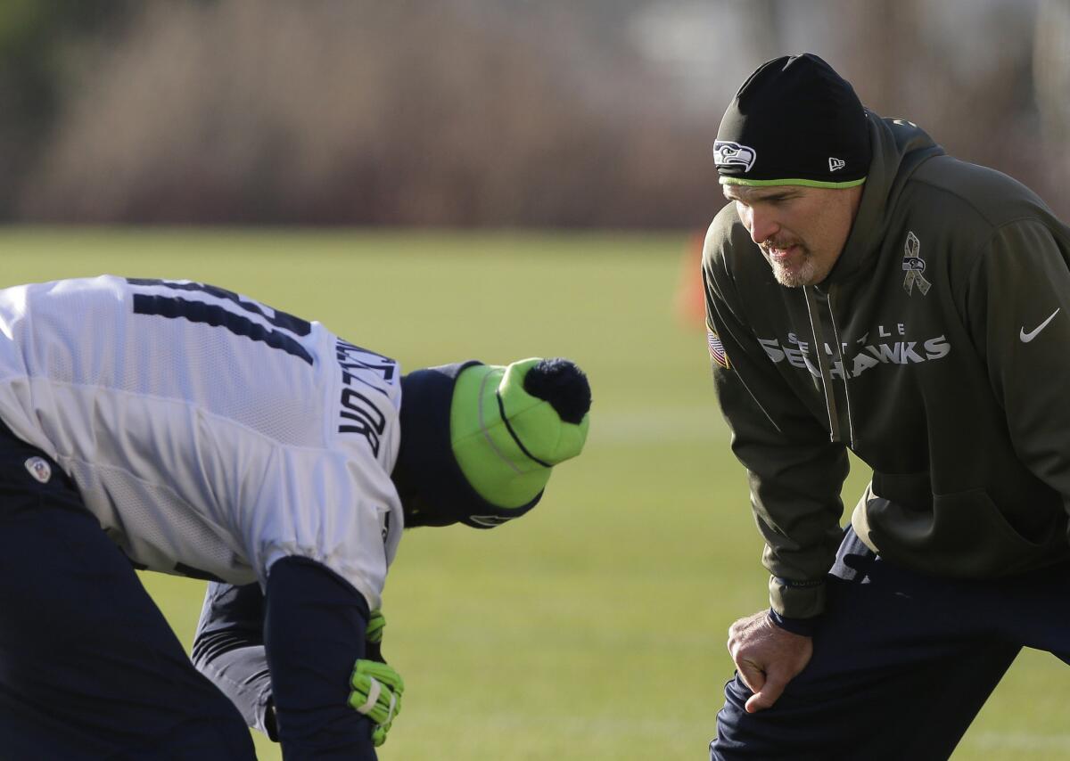 Seattle defensive coordinator Dan Quinn, right, talks to safety Kam Chancellor during warmups on Jan. 14.