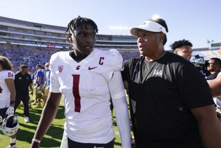 UCLA director of leadership Ken Niumatalolo greets Washington State quarterback Cameron Ward on the field after a game