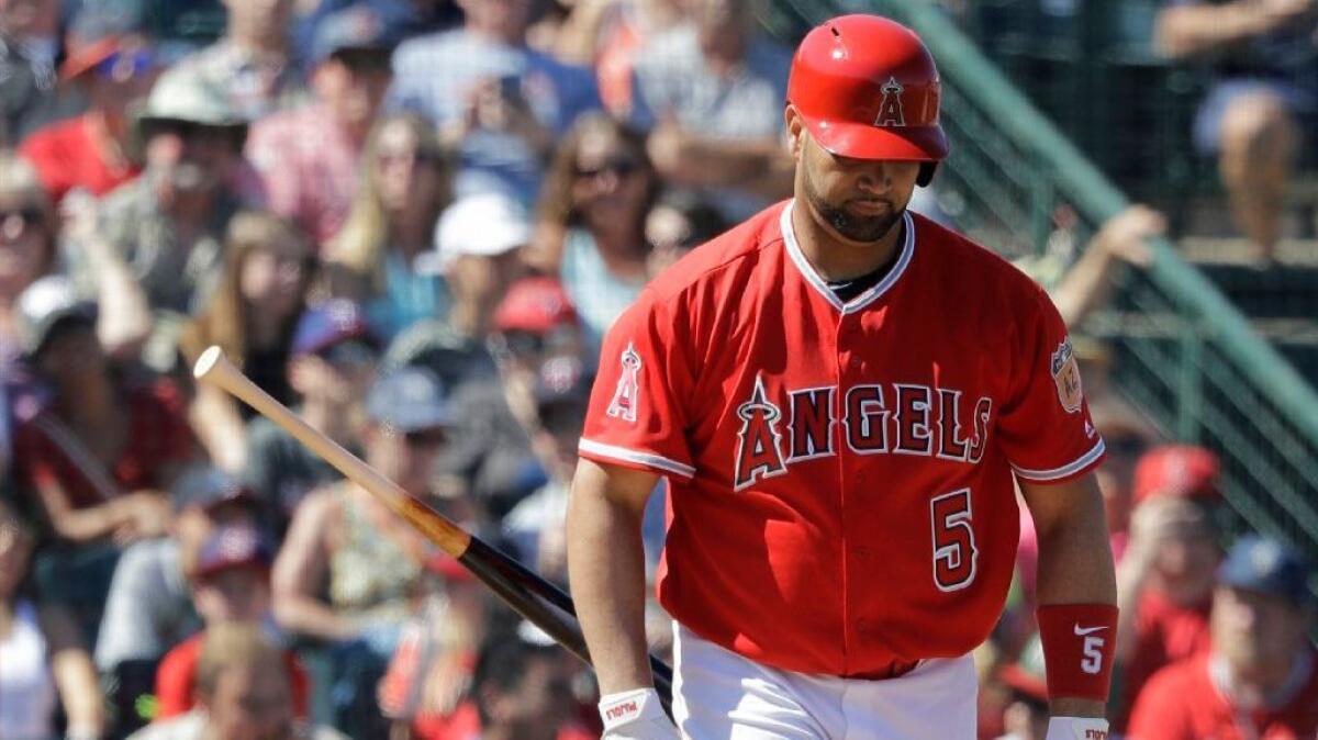 Angels designated hitter Albert Pujols tosses his bat after earning a walk in the third inning of Friday's spring training game against the San Diego Padres.