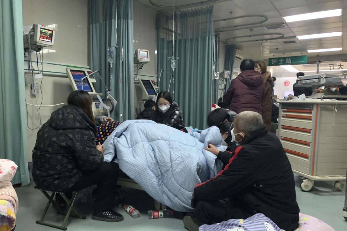 Varios familiares rodean la cama de un enfermo con COVID-19 en la zona de urgencias del Hospital Popular Langfang 