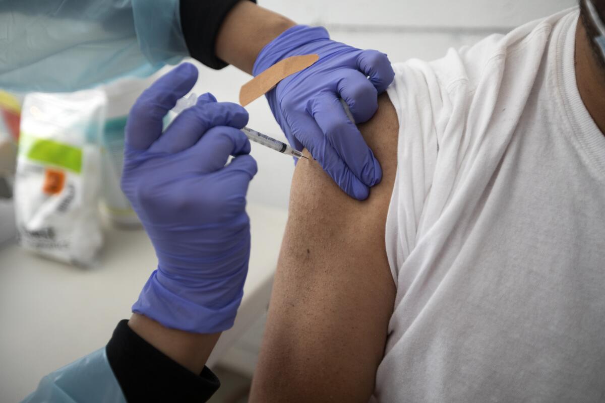 A medical assistant administers the Moderna COVID-19 vaccine. 