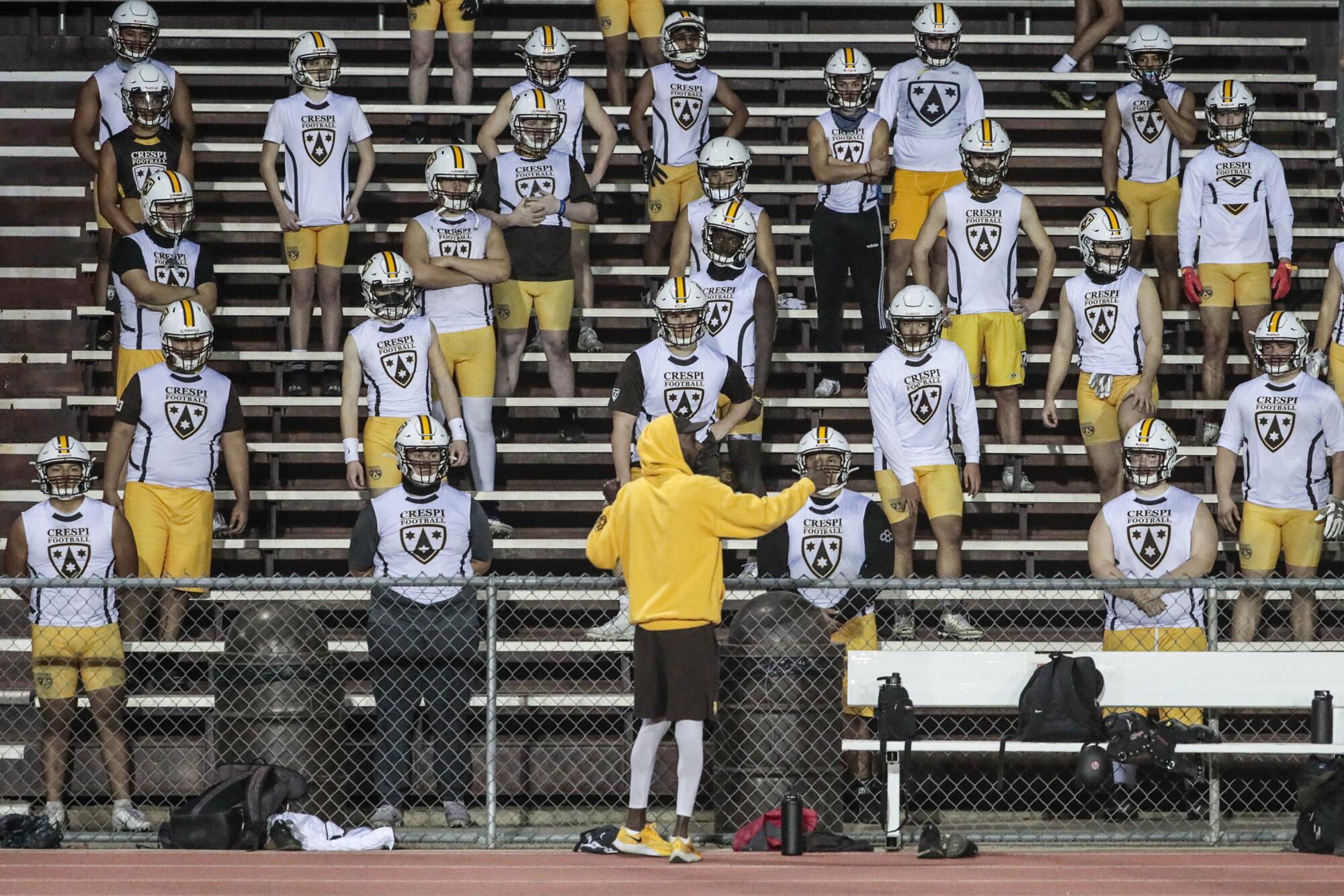 Crespi High School coach Dameon Porter, yellow sweatshirt, addresses his team.