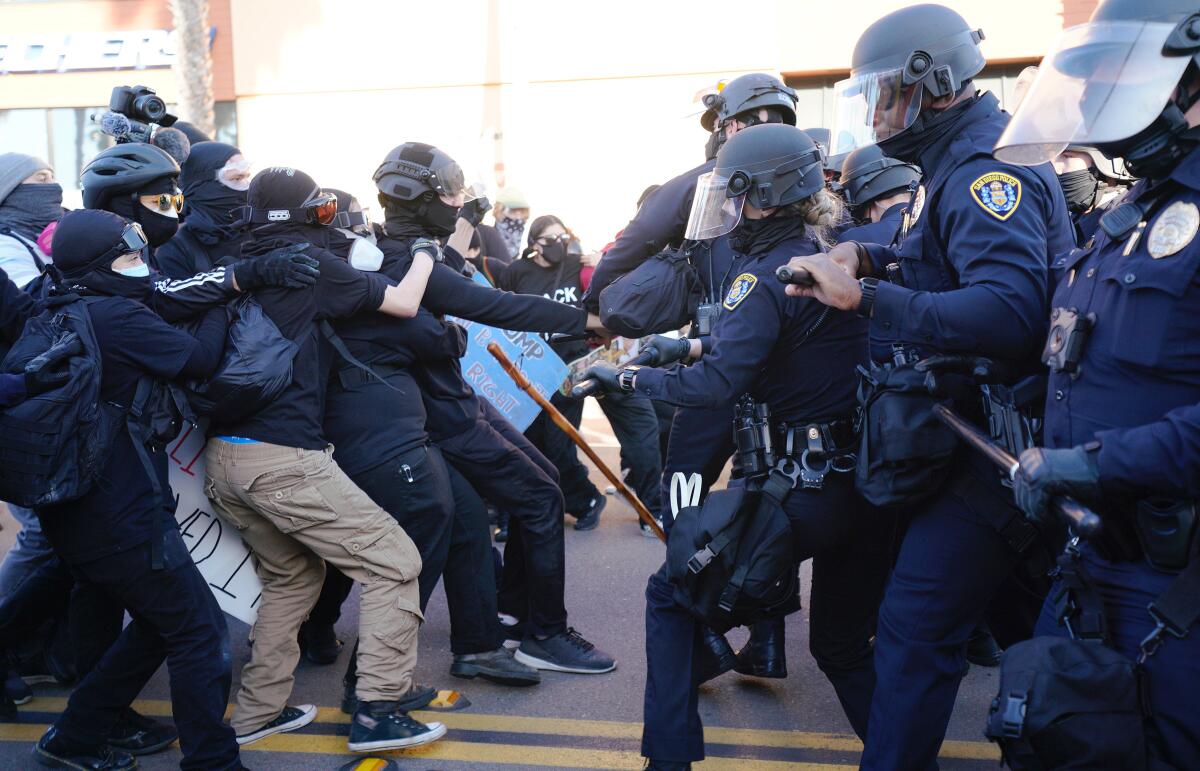 Jan. 2021 file photo, San Diego police officers push group of anti-fascist protesters countering a pro-Trump "Patriot March"