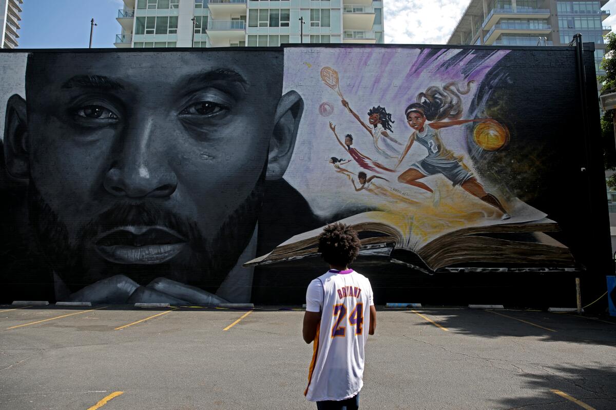 Illustrator Nikkolas Smith looks at a mural he created along with Odeith honoring the Kobe Bryant