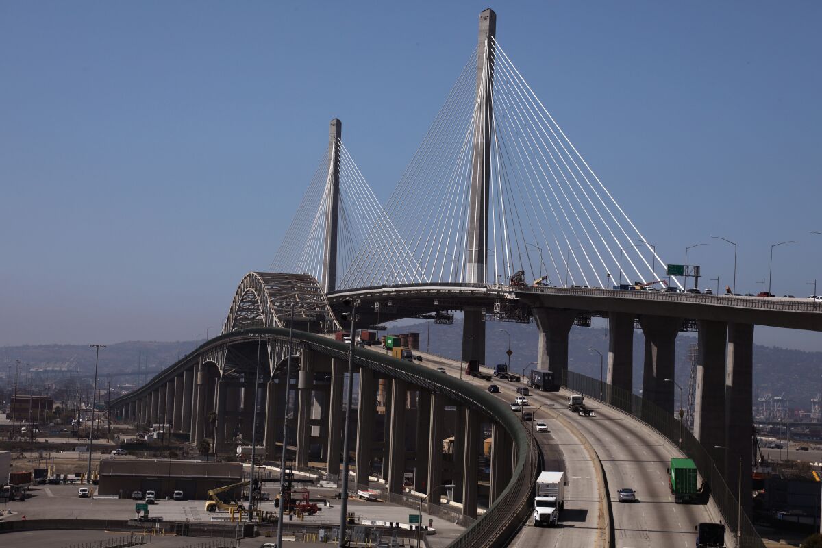 A tall, cable-stayed bridge next to a shorter bridge at the Long Beach port