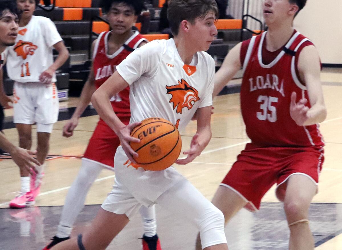 Philip Steinert (4) of Los Amigos drives to the basket against Loara on Friday night.