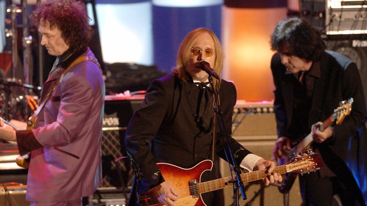 Tom Petty, center, and the Heartbreakers, perform after being inducted into the Rock and Roll Hall of Fame on March 18, 2002