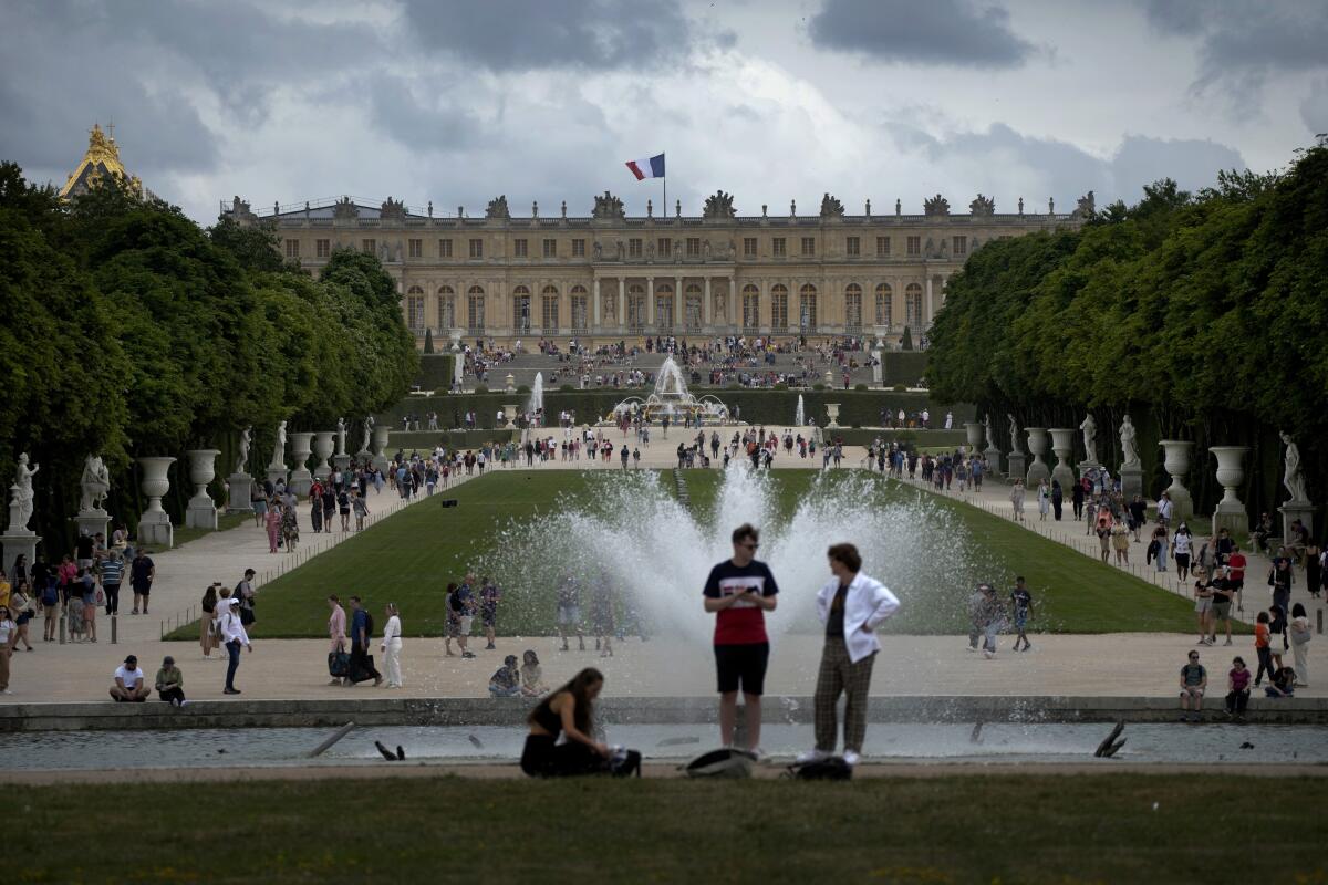 Turistas vistan el Palacio de Versalles y sus jardines en las afueras de París, 15 de julio de 2023.