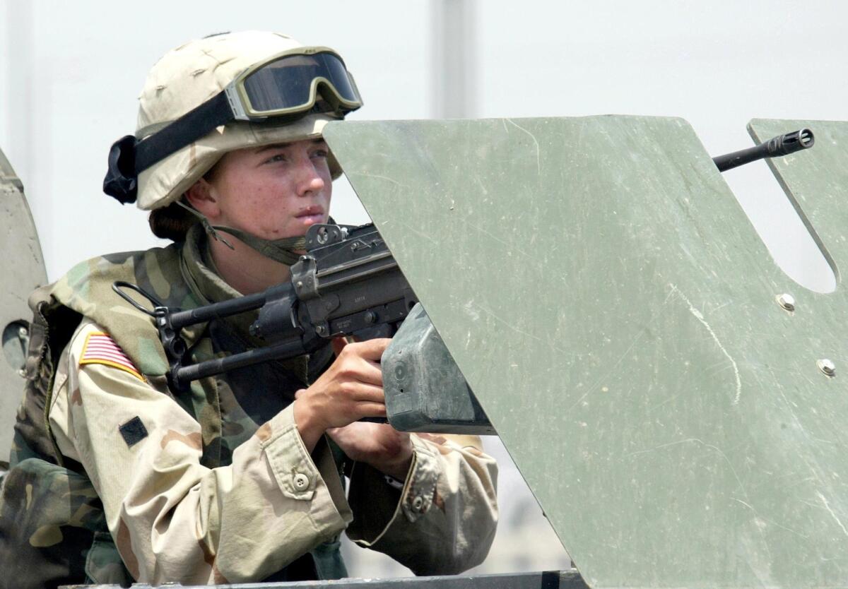 A female U.S. soldier manning a machine gun on a vehicle during clashes in the northern Iraqi city of Mosul.