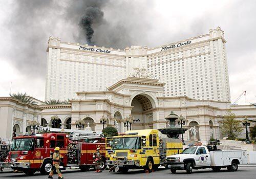 Emergency vehicles line up outside the entrance to the Monte Carlo Resort & Casino, where a three-alarm blaze broke out shortly before 11 a.m. today. The fire was reported contained about an hour later.