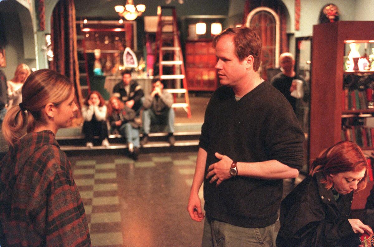 Joss Whedon, right, creator, writer and director of "Buffy the Vampire Slayer," talks to star Sarah Michelle Gellar on set in 2001.