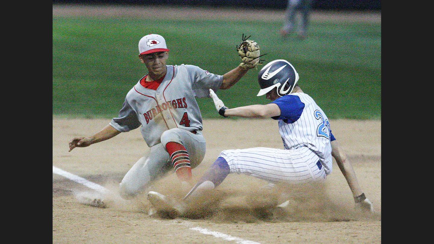 Burroughs' Ricky Perez, at third base, jumps to the base trying to get Burbank's Davis Mieliwocii out, but was called safe, in a rival cross-town Pacific League baseball game at Burbank High School on Tuesday, May 9, 2017.