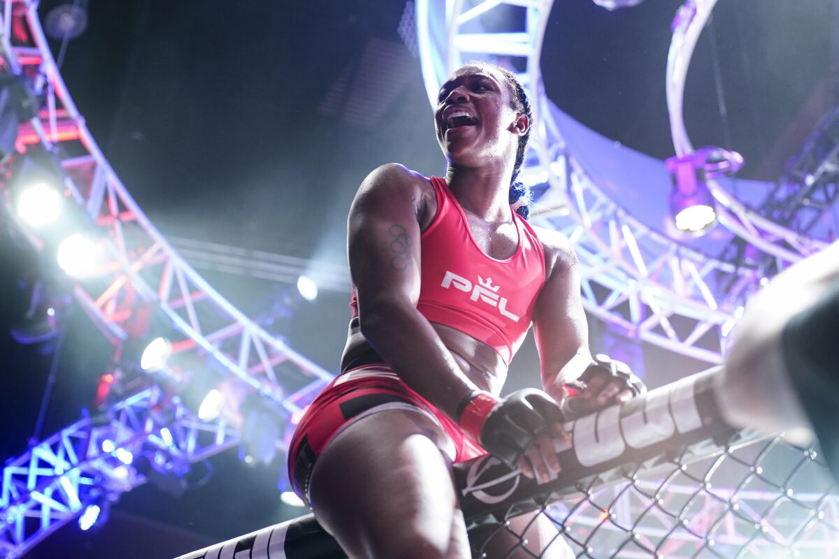 Claressa Shields climbs the cage after a Professional Fighters League mixed martial arts bout against Brittney Elkin in Atlantic City, N.J., Friday, June 11, 2021. (AP Photo/Matt Rourke)