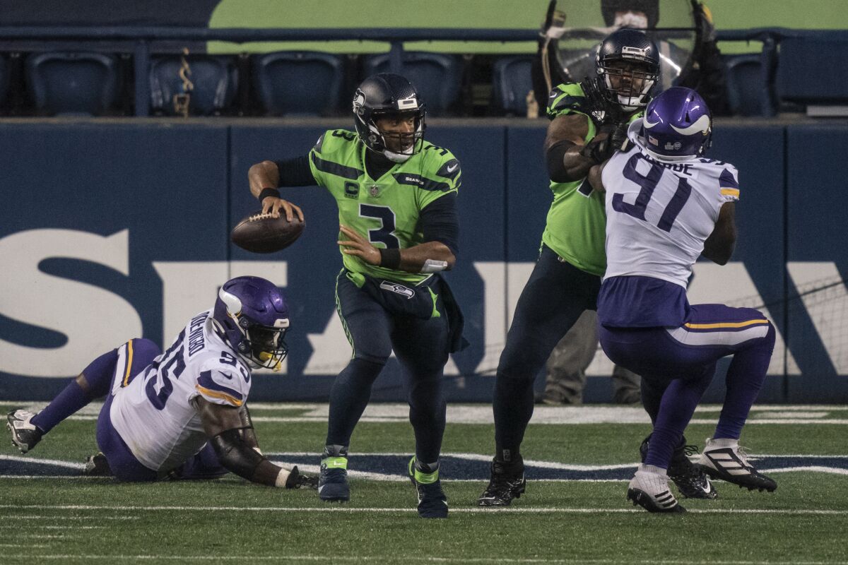 Seattle Seahawks quarterback Russell Wilson looks to passes before scrambling against the Minnesota Vikings.