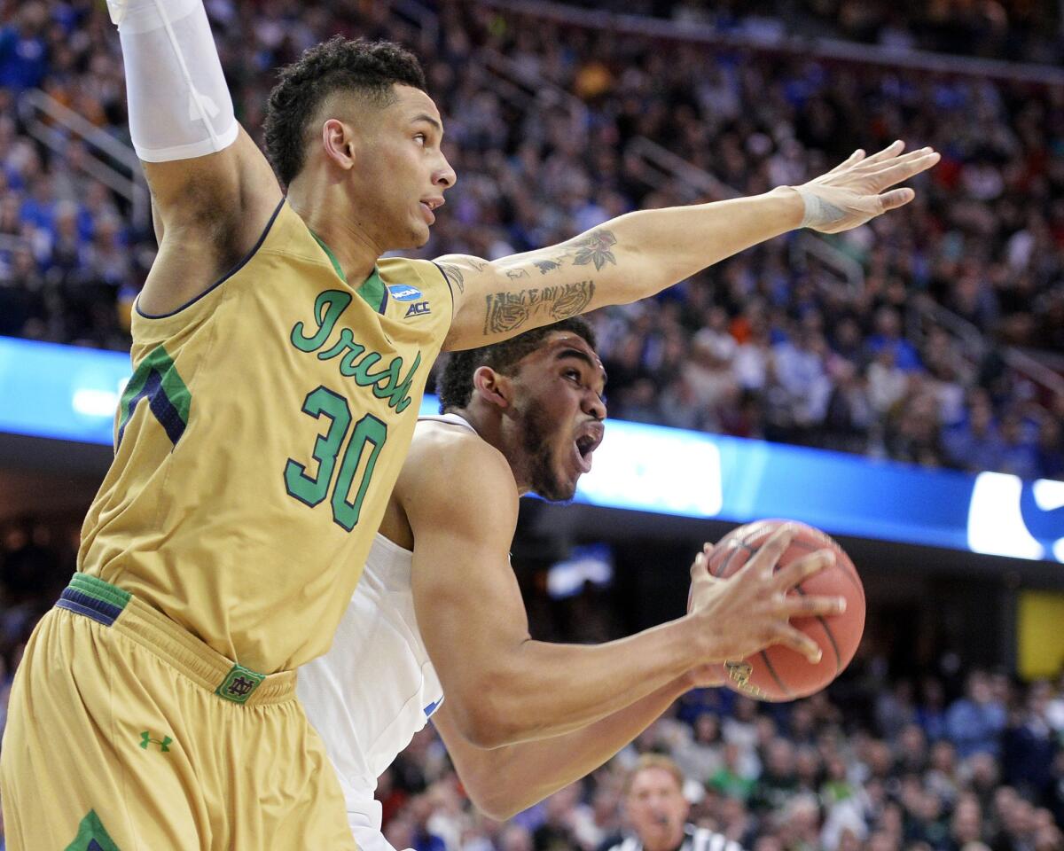 Kentucky center Karl-Anthony Towns works in the post against Notre Dame forward Zach Auguste in the first half of the Midwest Regional game Saturday. Towns finished with 25 points to lead the Wildcats.