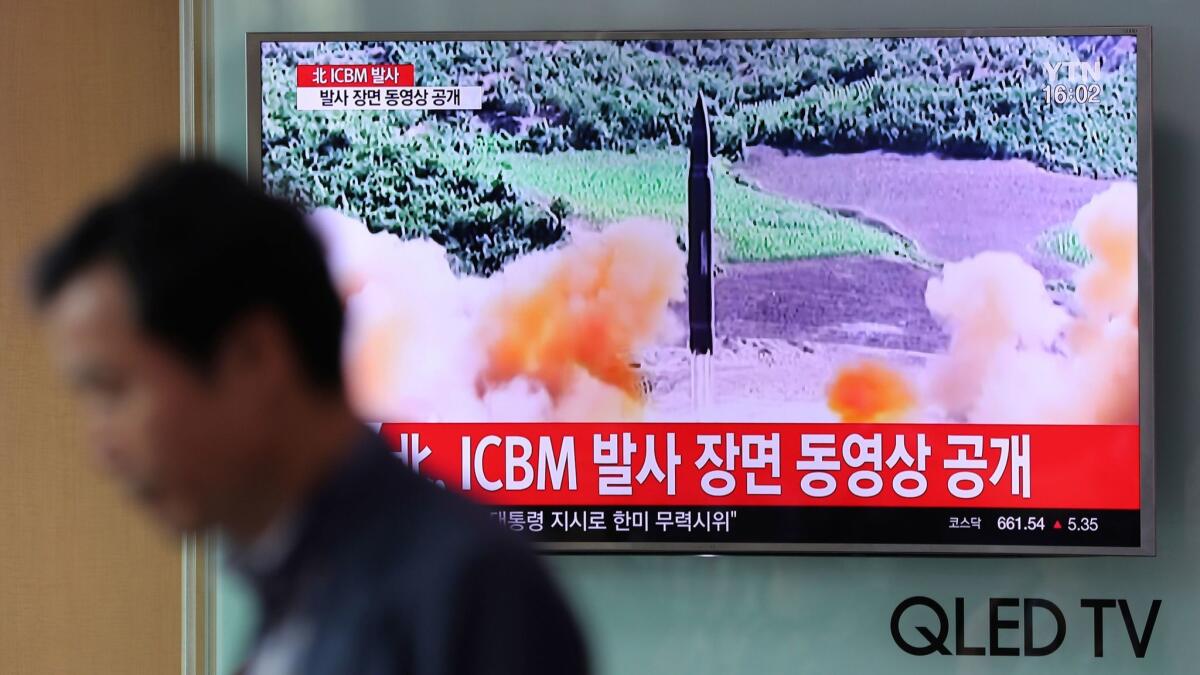 A man walks by a TV screen showing a news program reporting on North Korea's missile firing at Seoul Train Station in Seoul on Wednesday.