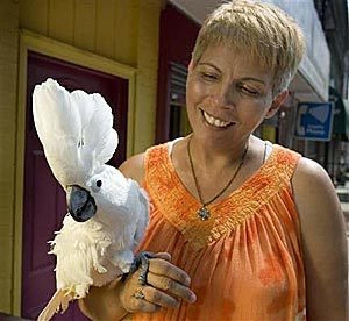 Evelyn DeLeon holds her umbrella cockatoo Luna in Trenton, N.J., yesterday. A persistent cry of "Help me! Help me!" coming from DeLeon's Trenton house turned out to be from the bird.