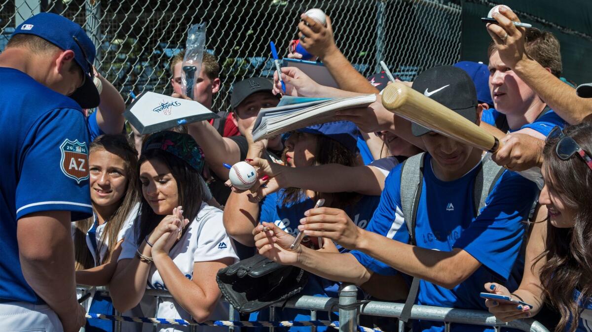 Fans jockey for position to get autographs from L.A. Dodger Corey Seager after a spring-training session in Arizona last year.