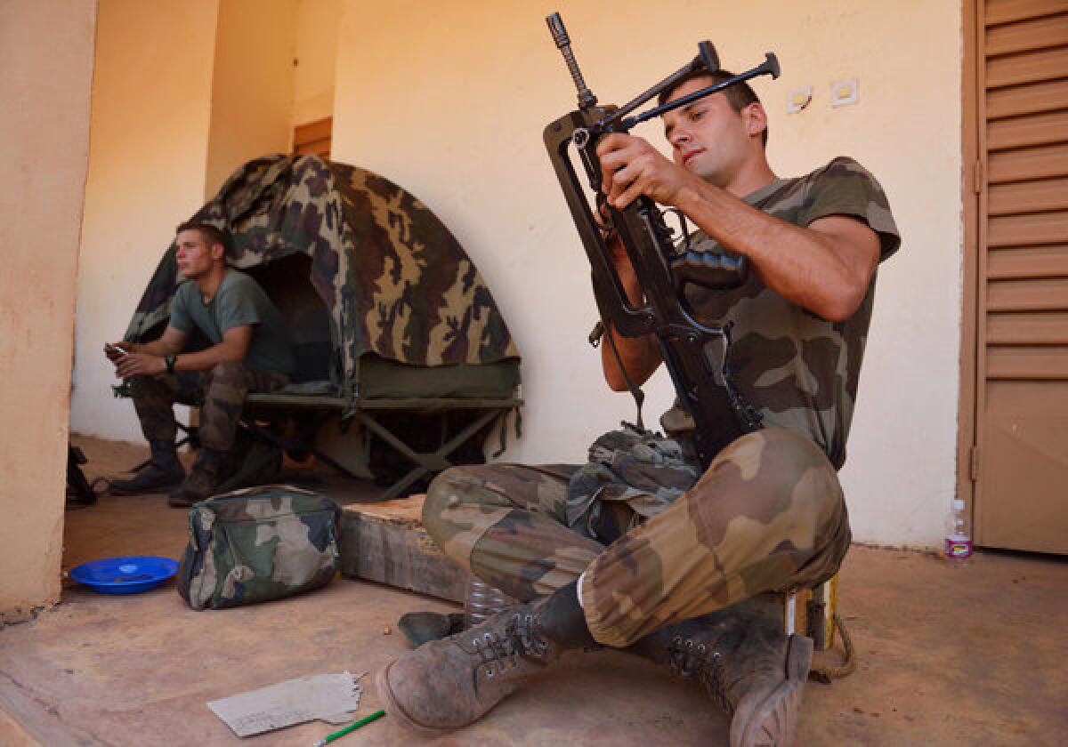 A French soldier from the 21st Marine Infantry Regiment prepares a FAMAS machine gun at a Malian army airbase near Bamako, Mali's capital.