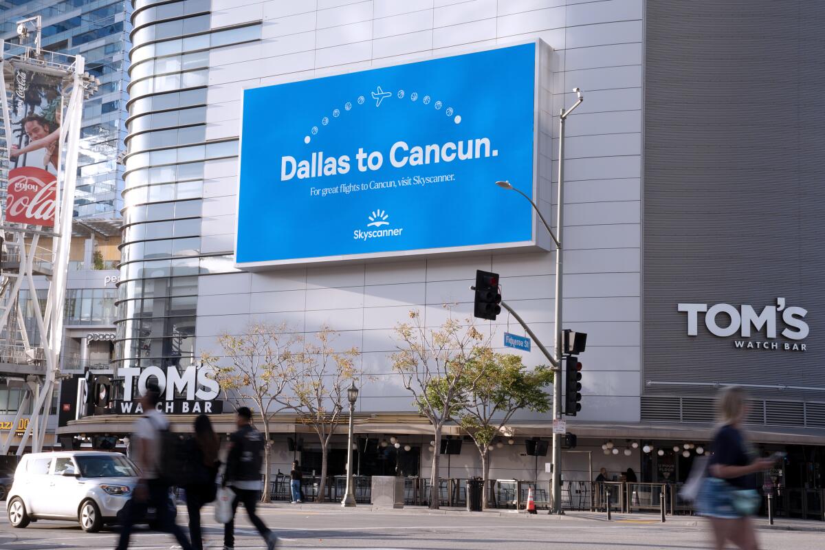 A "Dallas to Cancun" billboard is displayed across from Crypto.com Arena.