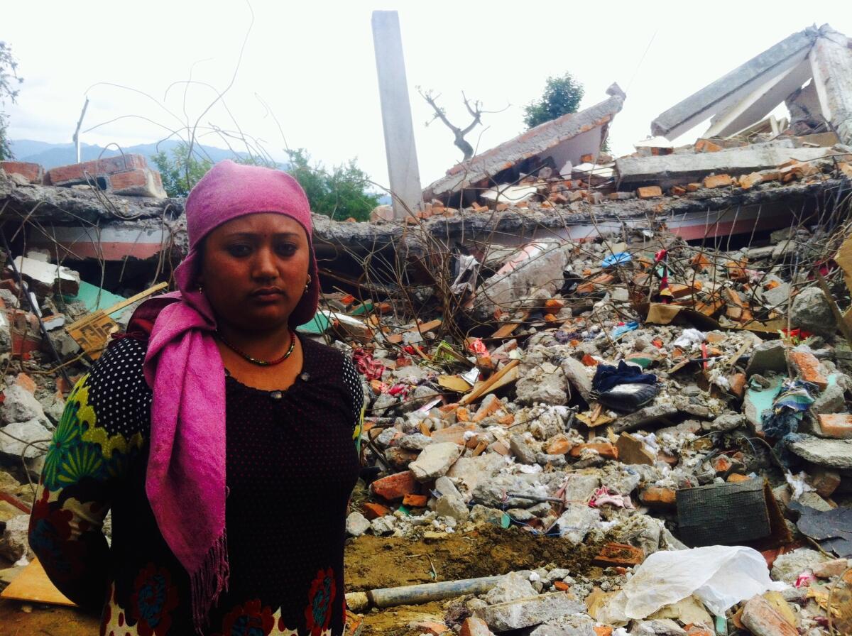 Prabina Shrastha stands in front of the wreckage of her home in Sangachok, Nepal.