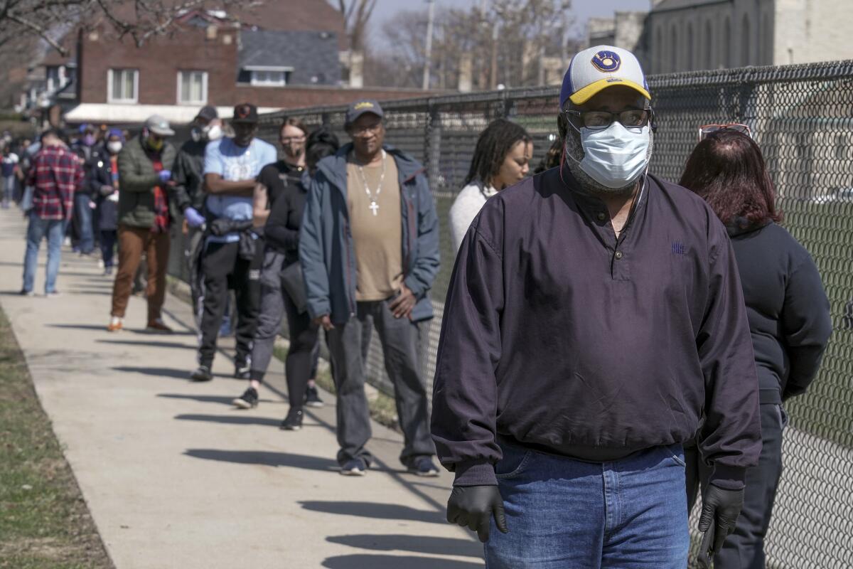 Black voters in Milwaukee wait in a socially distanced line to cast ballots in the April 2020 primary.