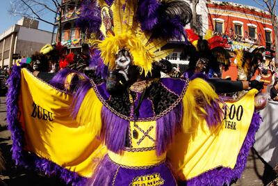 A member of the Zulu parade walks along St. Charles Avenue on Mardi Gras.