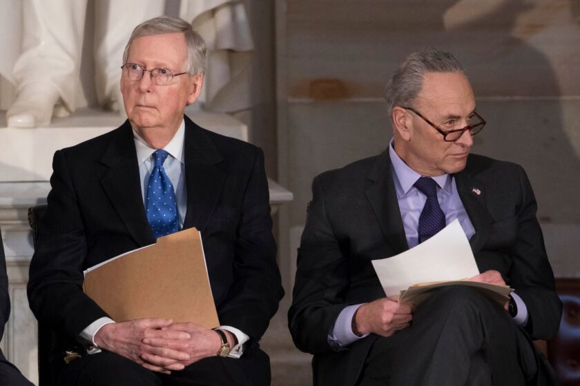 In this photo from Wednesday, Jan. 17, 2018, Senate Majority Leader Mitch McConnell, R-Ky., left, and Senate Minority Leader Chuck Schumer, D-N.Y., sit together to honor former Sen. Bob Dole, at the Capitol in Washington, Wednesday, Jan. 17, 2018. Schumer, arguably the most powerful Democrat in Washington, is trying to keep his party together to force a spending bill that would include protections for young immigrants, even as the federal government shutdown enters a third day. (AP Photo/J. Scott Applewhite)