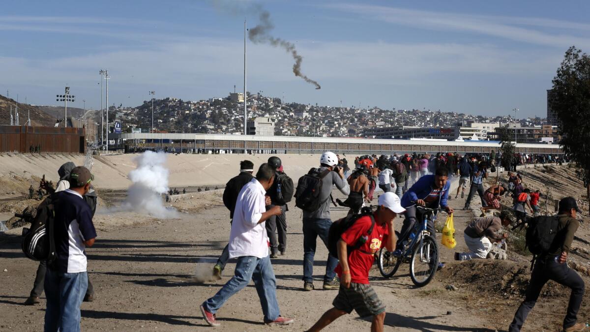 U.S. Border Patrol deploy tear gas on migrants refusing to step away from the concertina wire set up along the U.S. Mexico border near San Ysidro on Sunday, Nov. 25.