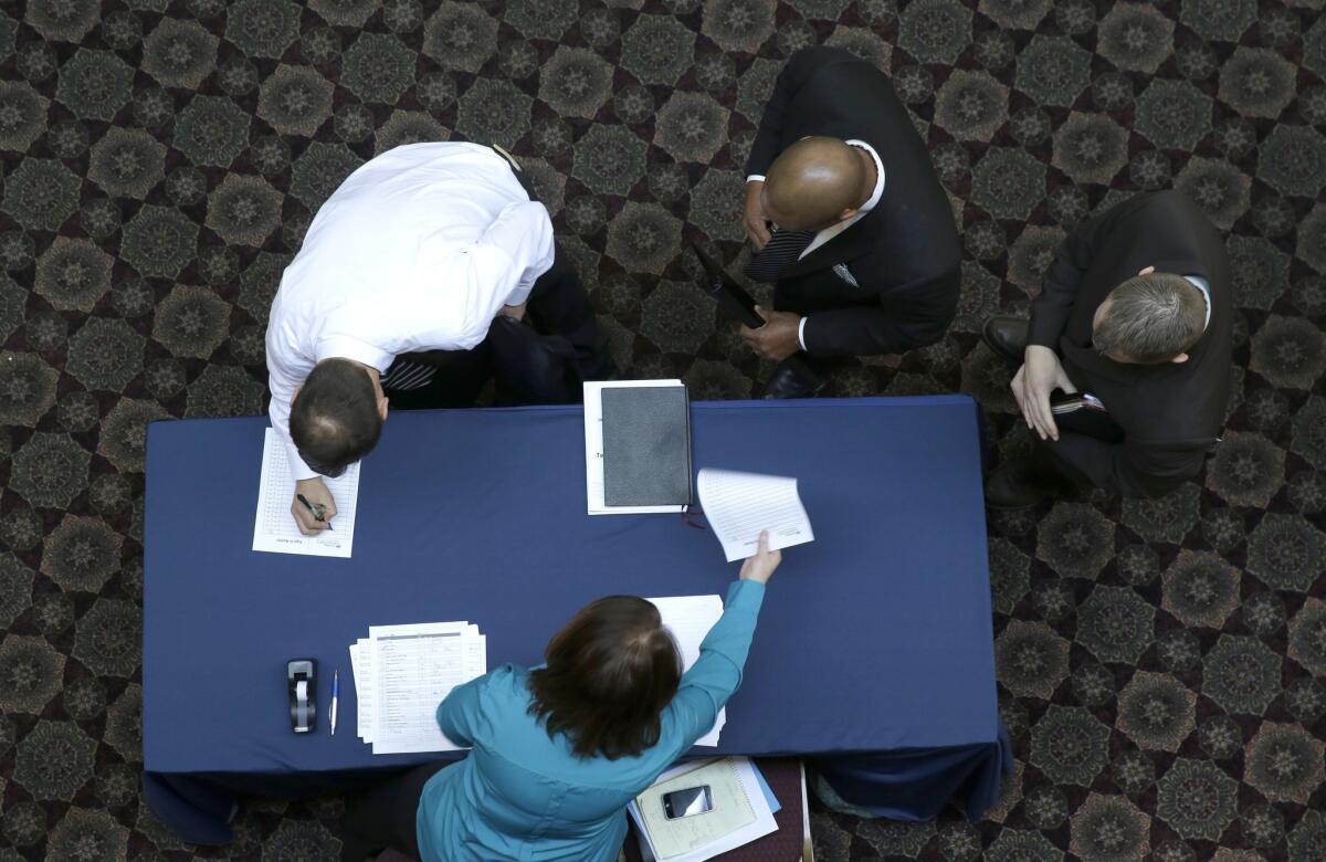The Congressional Budget Office foresees only modest job growth ahead and the unemployment rate to end this year at about the same 6.7% rate where it was in December. Above, job seekers sign in at a career fair in Dallas last month.