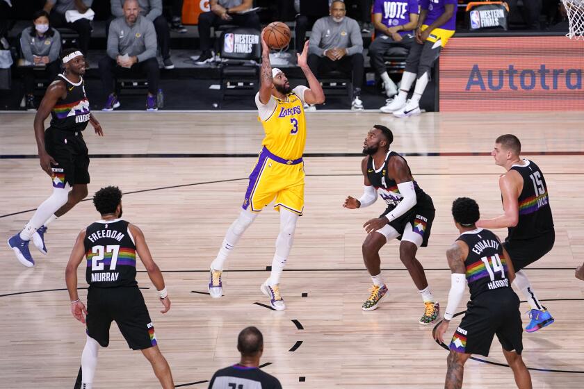 Los Angeles Lakers' Anthony Davis (3) drives against Denver Nuggets' Paul Millsap (4) during the first half of an NBA conference final playoff basketball game Thursday, Sept. 24, 2020, in Lake Buena Vista, Fla. (AP Photo/Mark J. Terrill)