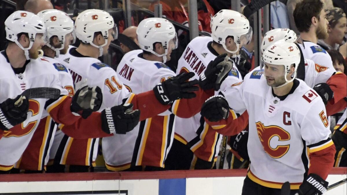 Calgary Flames defenseman Mark Giordano, right, gets teammates' congrats after scoring a goal against the New Jersey Devils on Feb. 27.