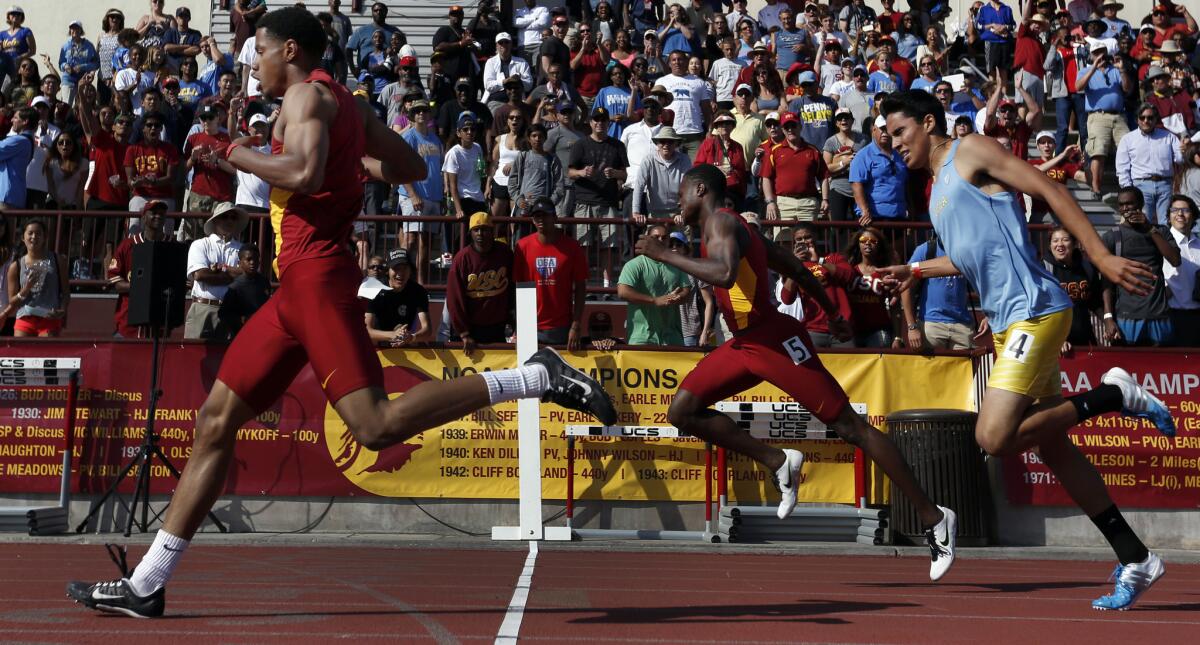 USC senior Davonte Stewart, left, crosses the finish line first during the men's 400 meter dash in the USC-UCLA track meet.