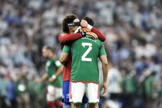El guardameta mexicano Guillermo Ochoa abraza a su compañero Néstor Araujo al inicio del encuentro de la Copa Mundial ante Argentina el sábado 26 de noviembre del 2022 en Doha, Qatar. (AP Foto/Hassan Ammar)