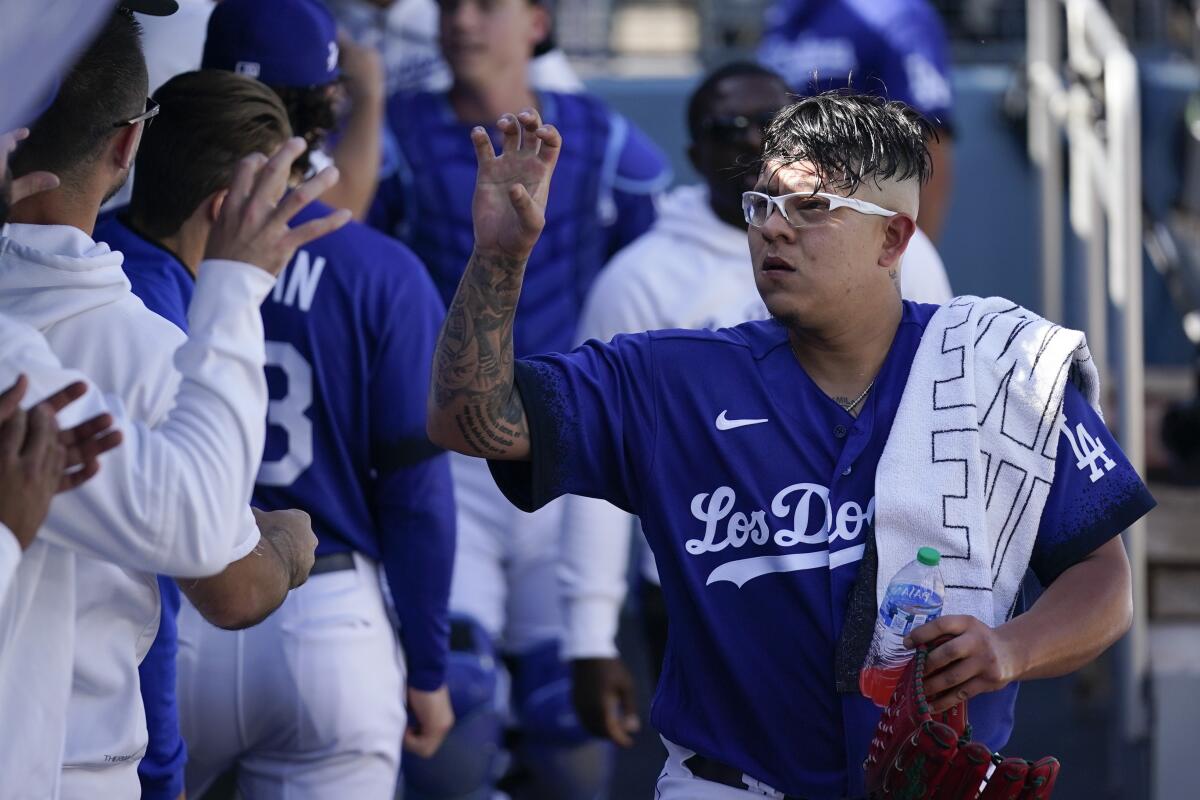 Dodgers starting pitcher Julio Urías is greeted in the dugout before Saturday's game against the Padres.