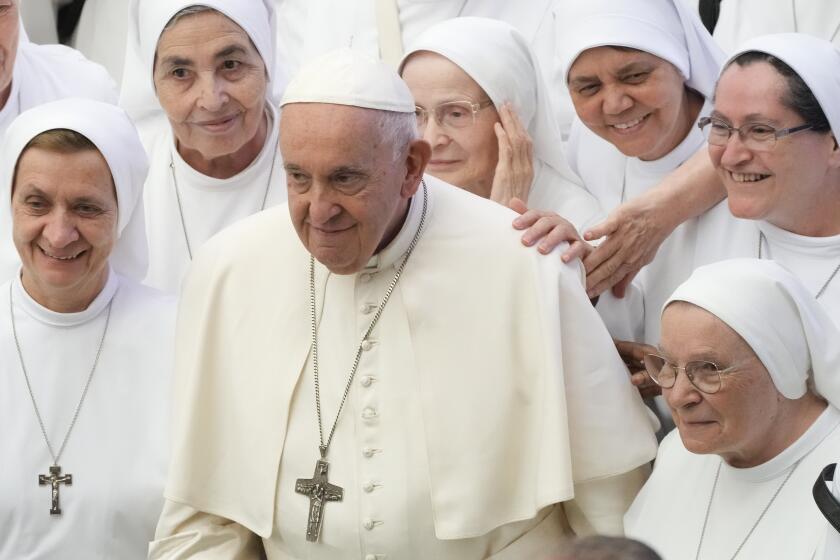 Pope Francis poses for a picture with a group of nuns during the general audience in the Paul VI hall at the Vatican, Wednesday, Aug. 9, 2023. (AP Photo/Gregorio Borgia)