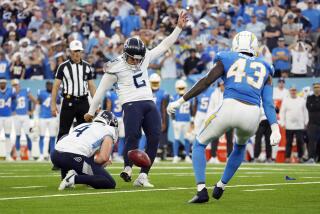 The Titans' Nick Folk kicks a game-winning field goal in overtime as the Chargers' Michael Davis (43) rushes.