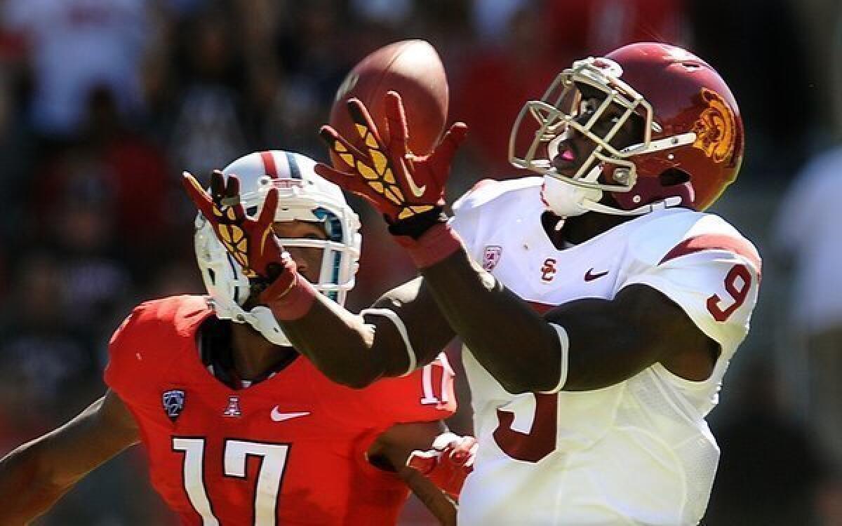 Trojans receiver Marqise Lee hauls in a pass against Wildcats cornerback Derrick Rainey on a 57-yard touchdown play in the first half Saturday.